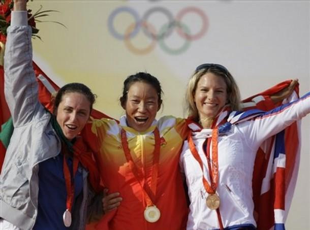 beijing_sensini_35.jpg - Flanked by Italy's Alessandra Sensini, left, who won silver, and Britain's Bryony Shaw, right, who took bronze, China's gold medalist Yin Jian, center, celebrates during the medal ceremony of the RS:X women class sailing competition of the 2008 Beijing Olympics in Qingdao, about 720 kilometers southeast of Beijing, Wednesday, Aug. 20, 2008.  AP Photo/Herbert Knosowski)