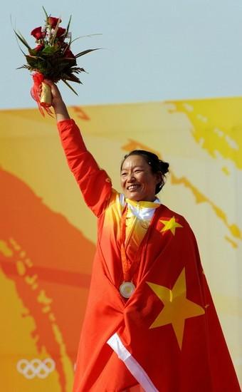 beijing_sensini_34.jpg - Yin Jian of China celebrates her gold medal on the podium of the windsurfing RS:X  women's class at the 2008 Beijing Olympic Games on August 2008, 2008 at the Olympic sailing center in Qingdao. Alessandra Sensini of Italy took silver and Bryony Shaw of Britain claimed bronze. AFP PHOTO/DON EMMERT (Photo credit should read DON EMMERT/AFP/Getty Images)