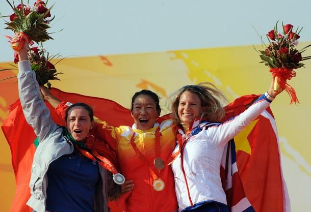 beijing_sensini_42.jpg - (From L) Silver medalist Alessandra Sensini of Italy, gold medalist Yin Jian of China and bronze medalist Bryony Shaw of Britain celebrate on the podium of the windsurfing RS:X  women's class at the 2008 Beijing Olympic Games on August 20, 2008 at the Olympic sailing center in Qingdao. AFP PHOTO/DON EMMERT (Photo credit should read DON EMMERT/AFP/Getty Images)